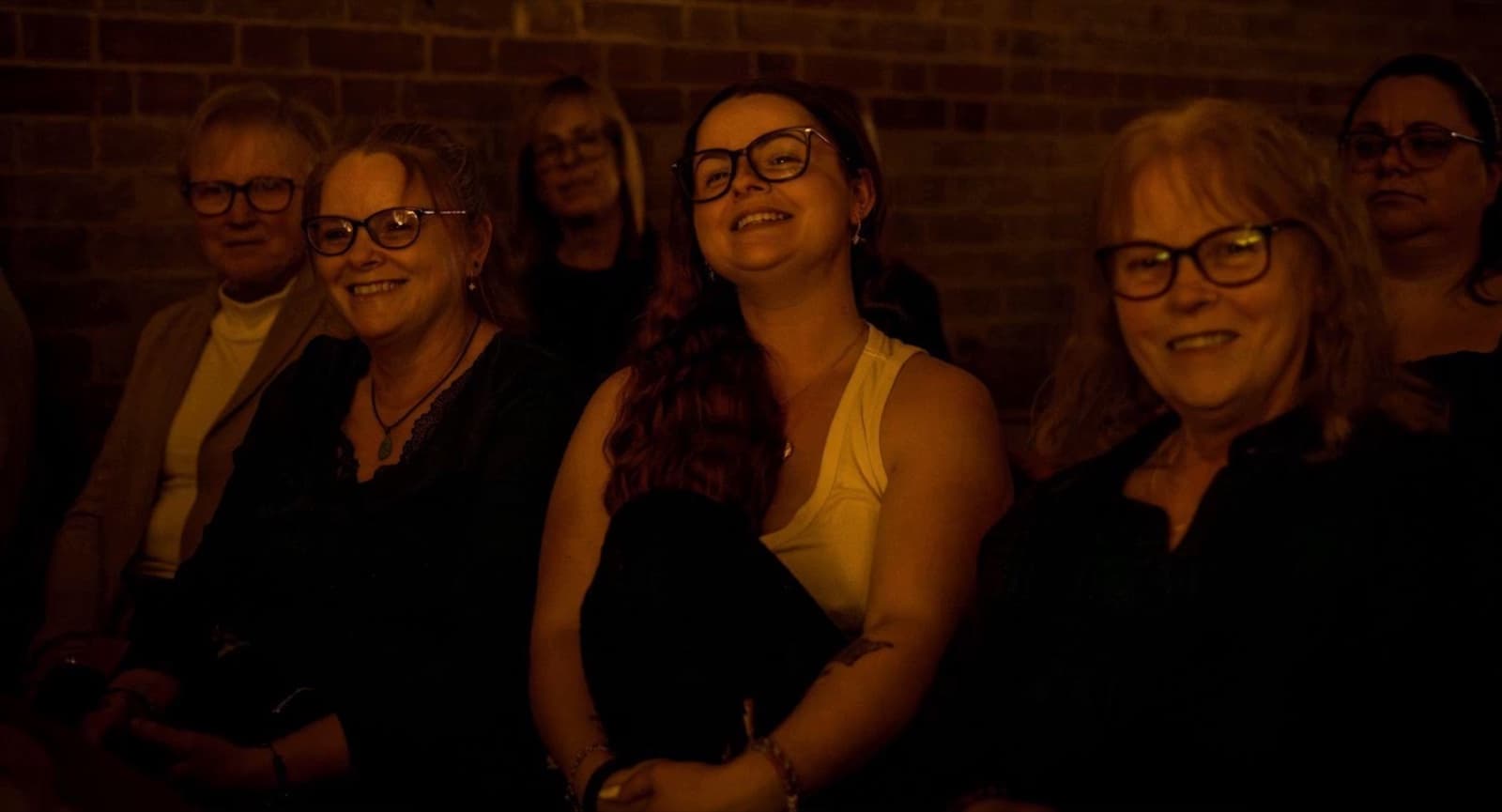 A warmly lit audience enjoying a candlelit Lumos concert