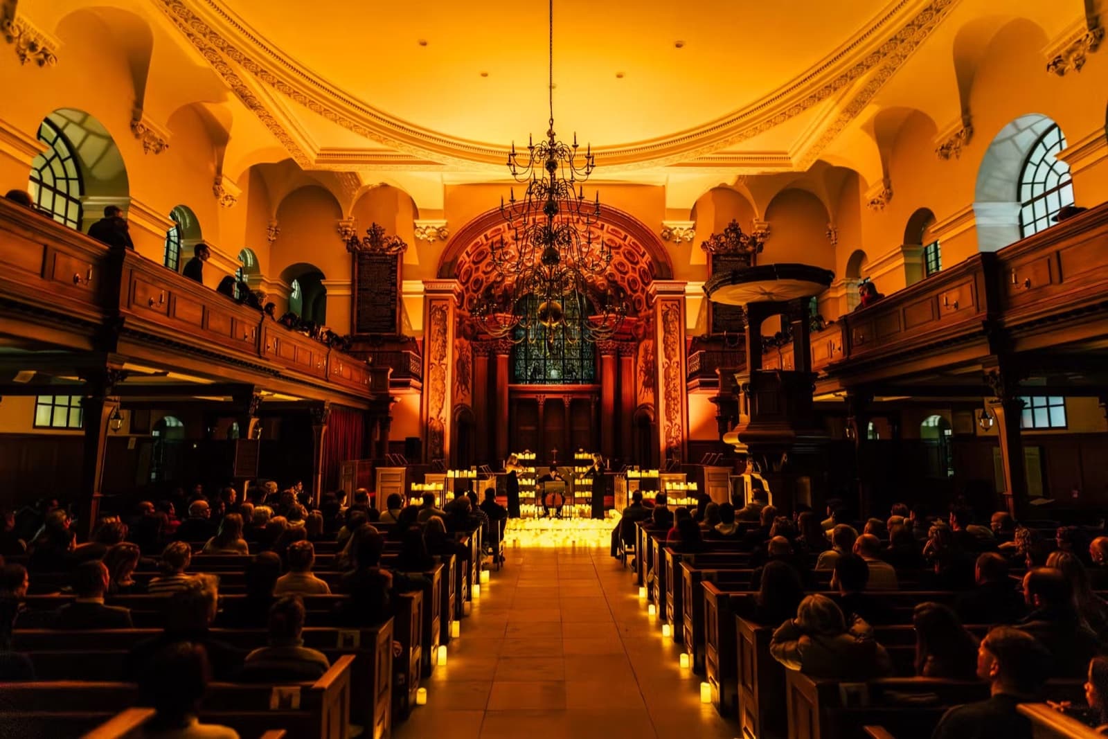 A grand candlelit venue with musicians performing to a full audience