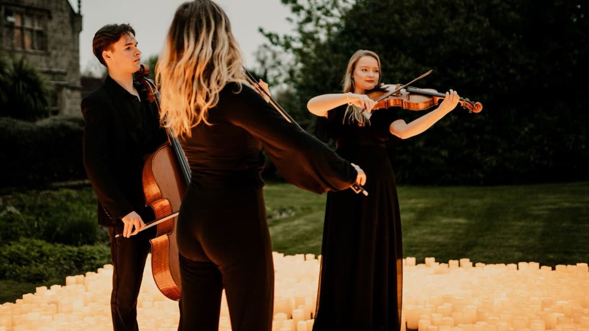Trio performing outdoors at dusk