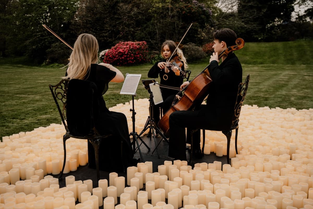 Trio performing outdoors among candles