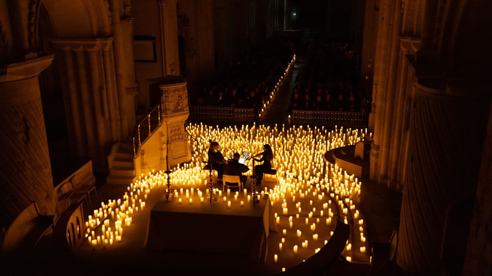 Candlelit aisle inside a historic venue set up for a private event