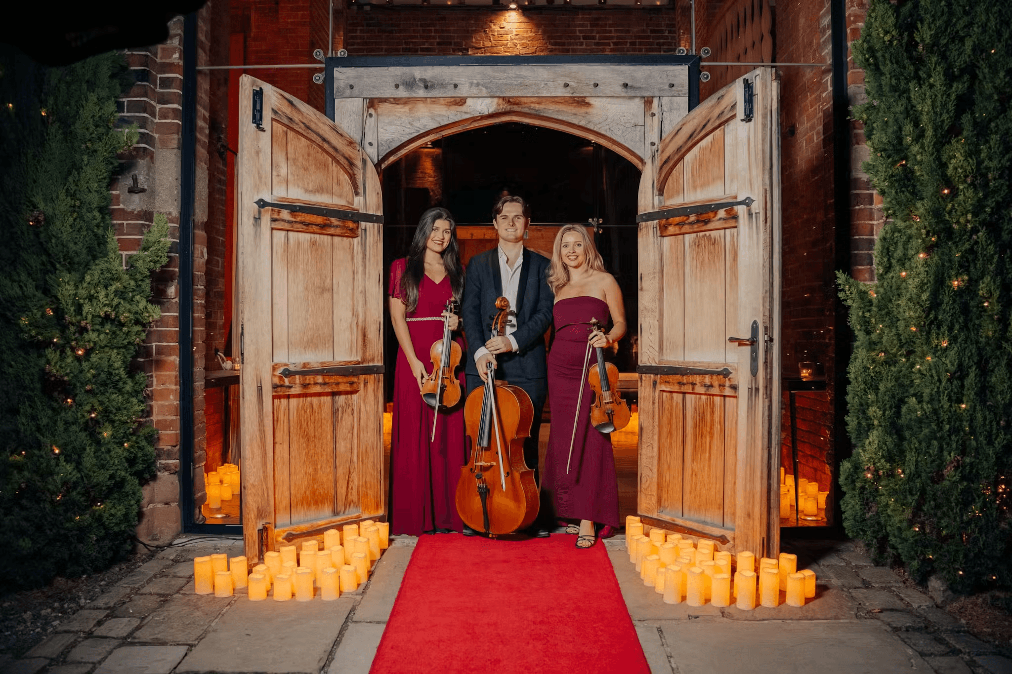 Musicians arriving at a candlelit venue entrance